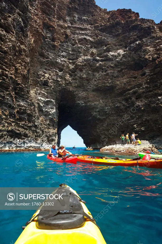 Hawaii, Kauai, Na Pali Coast, Group of kayakers exploring sea cave along coastline. Editorial Use Only.