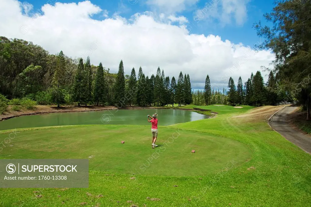 Hawaii, Lanai, Woman playing golf at The Experience at Koele Golf Course.