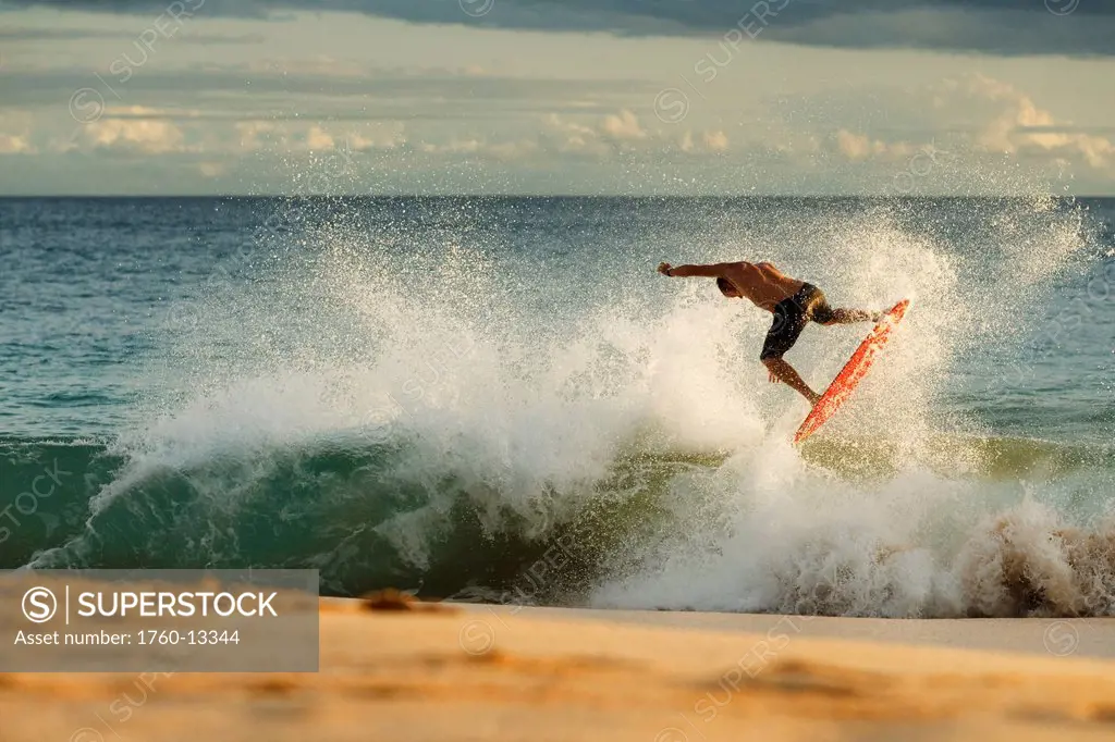 Hawaii, Maui, Makena _ Big Beach, Man skimboarding shoreline surf.