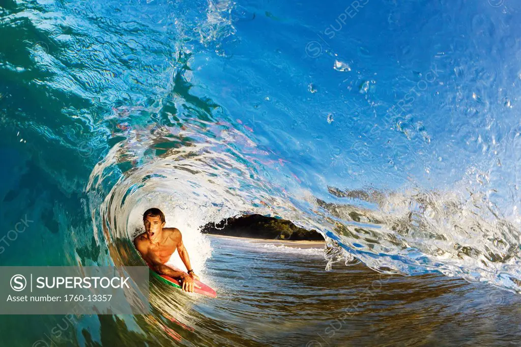 Hawaii, Maui, Makena _ Big Beach, Boogie boarder riding barrel of beautiful wave, Sunrise light.