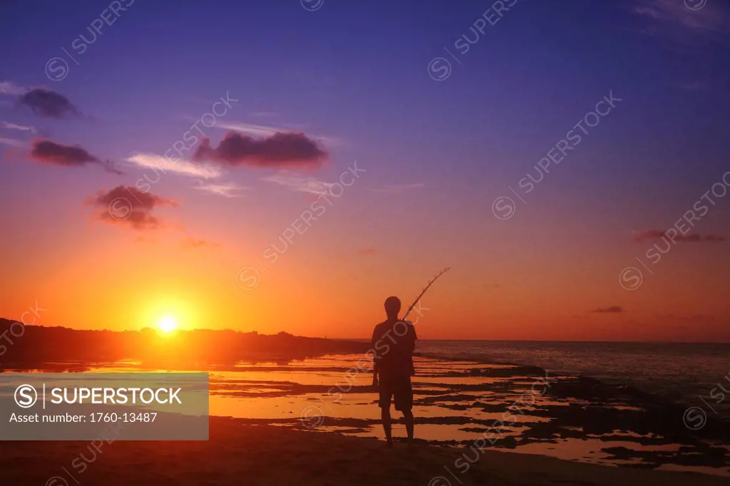 Hawaii, Silhouetted fisherman and sunset.