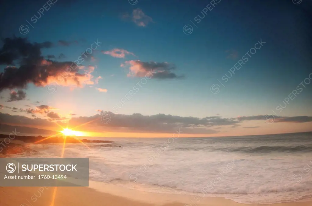 Hawaii, Oahu, North Shore, Beautiful sunset over ocean with dog on beach.