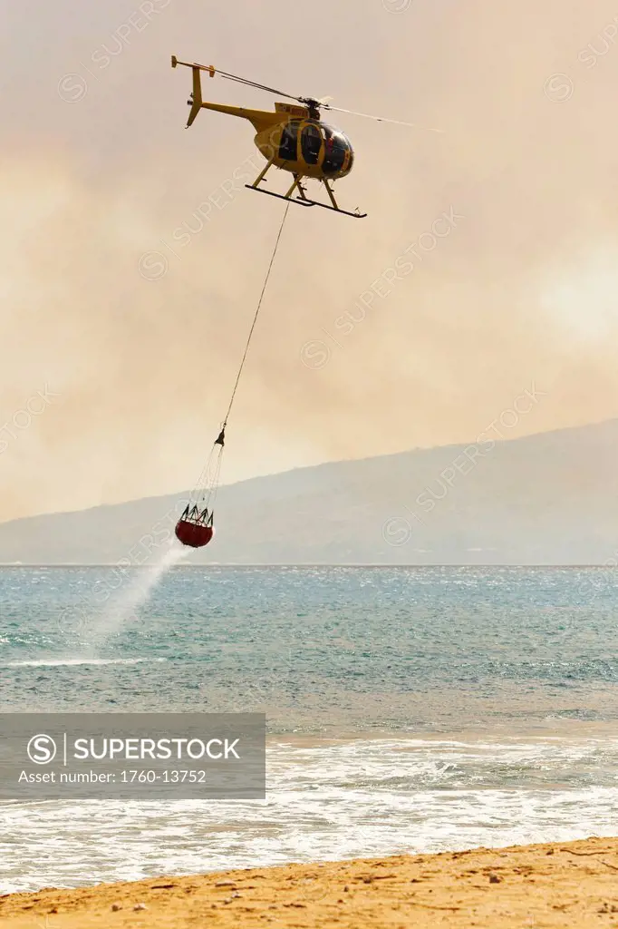Hawaii, Maui, Ma´alaea, Fire helicopter collecting ocean water to help put out wildfire. Editorial Use Only.