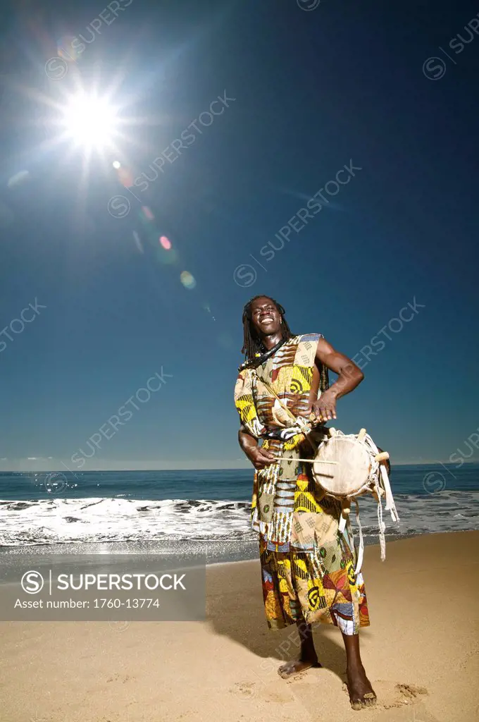 Hawaii, Kauai, Kealia Beach, African dancer on shore with drum.