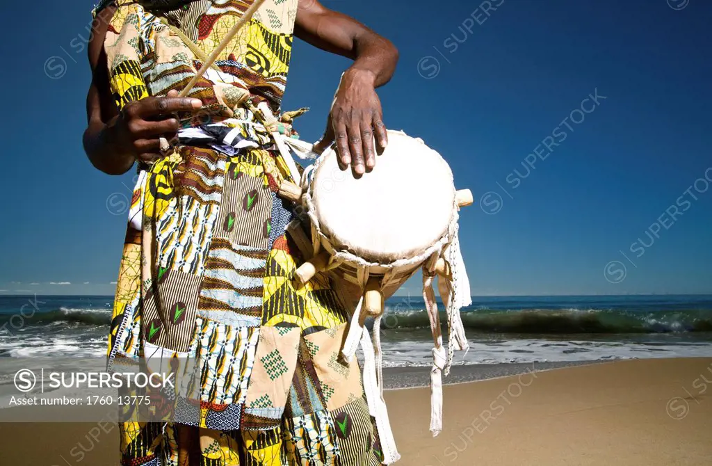 Hawaii, Kauai, Kealia Beach, African Dancer with drum on shore.