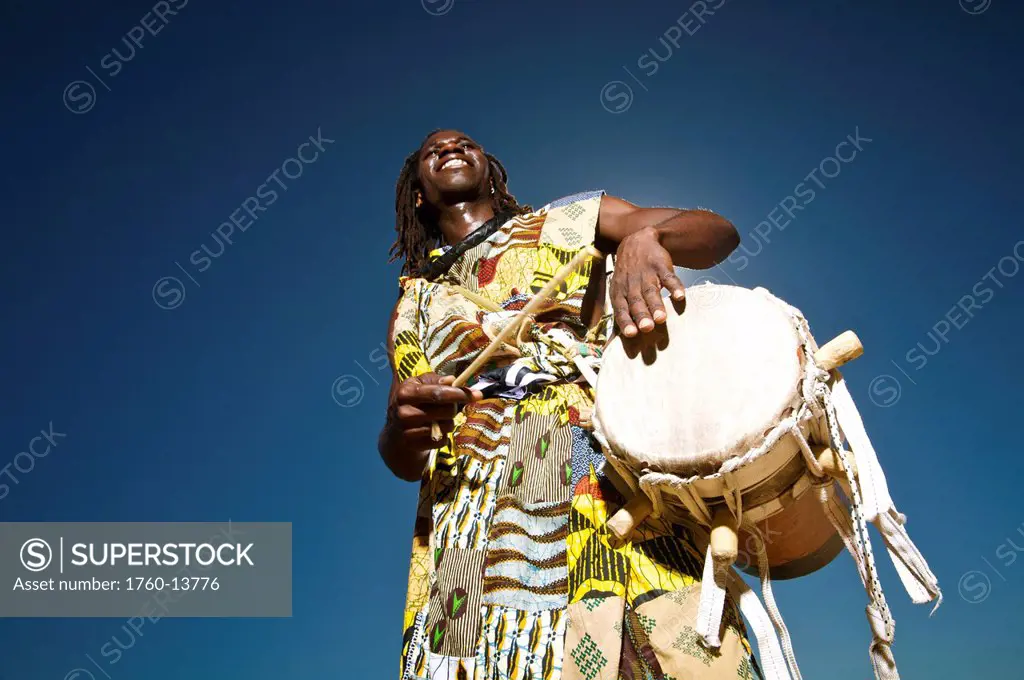 Hawaii, Kauai, Kealia Beach, African Dancer with drum, Angled view from below.