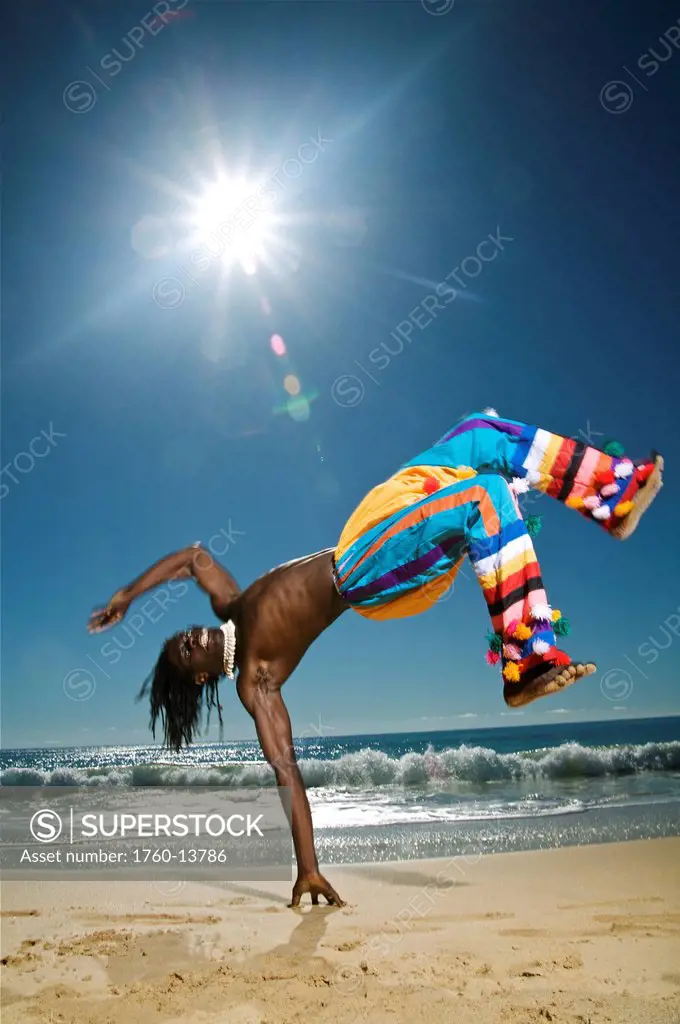 Hawaii, Kauai, Kealia Beach, African dancer on sandy shore.