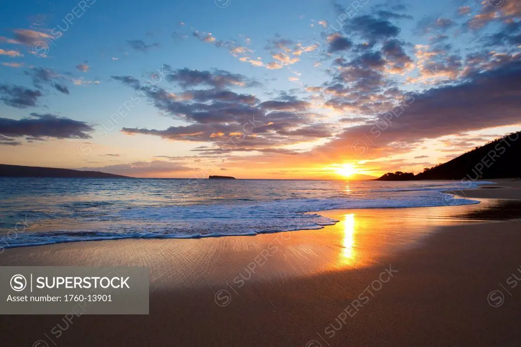 Hawaii, Maui, Makena _ Big Beach, Beautiful sunset over ocean and shoreline, Molokini island in distance.