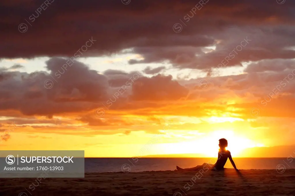 Hawaii, Maui, Makena, Person on beach enjoying beautiful sunset over ocean and shoreline. Editorial Use Only.