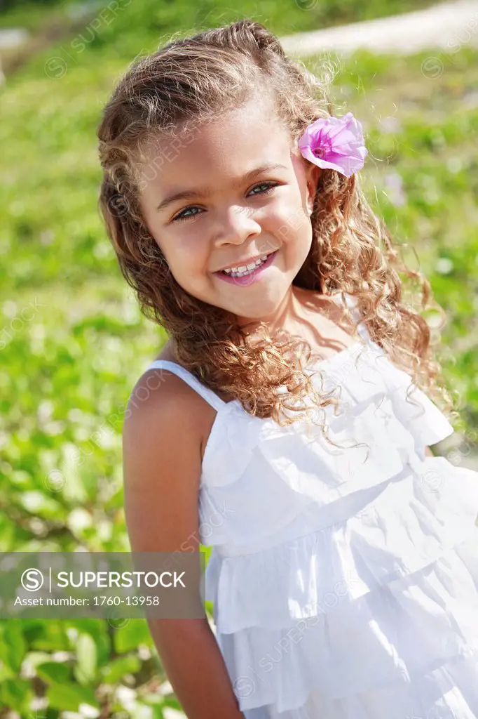 Hawaii, Oahu, Lanikai, Young girl Poses with flower in her hair.