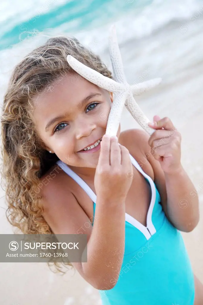 Hawaii, Oahu, Lanikai, Young girl with starfish at beach.
