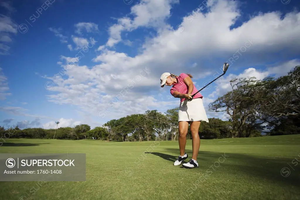 Hawaii, Maui, Wailea Gold Golf Course, Female golfer swinging golf club.