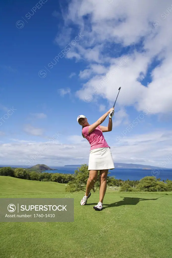 Hawaii, Maui, Wailea Gold Golf Course, Female golfer swinging golf club.