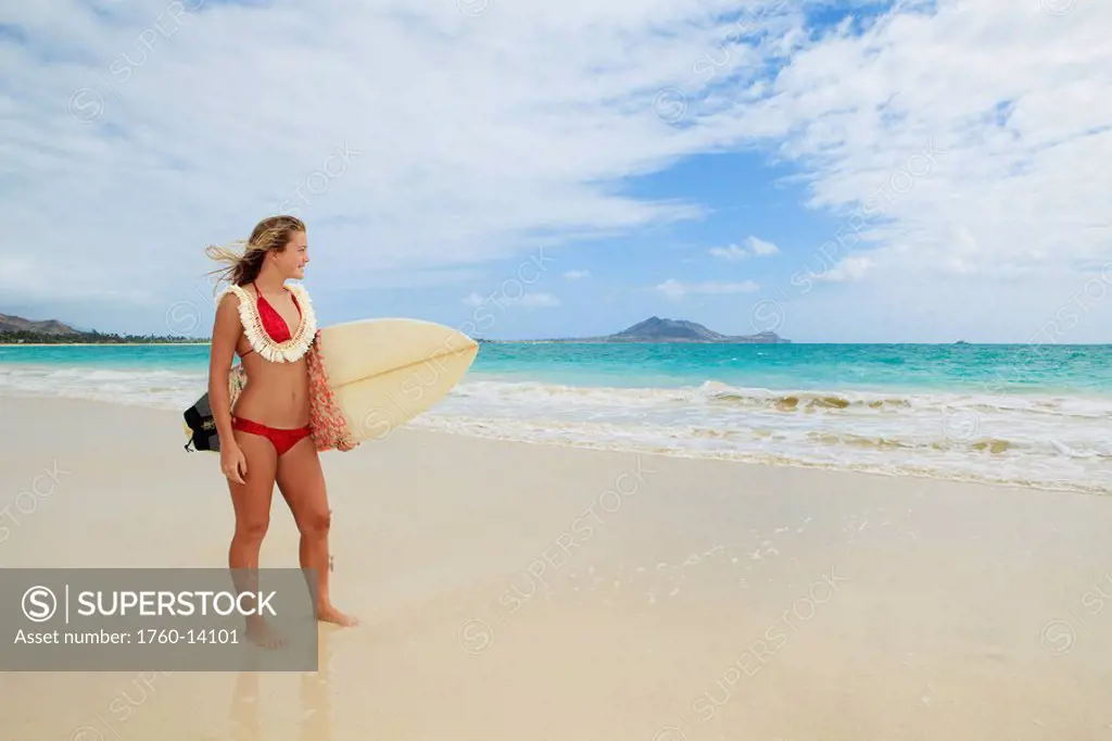 Hawaii, Oahu, Kailua Beach, Teenage girl holding surfboard on beach.