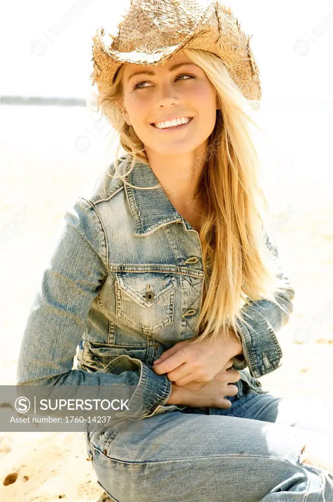 Hawaii, Kauai, Kealia, Beautiful young model poses on beach with cowboy hat.