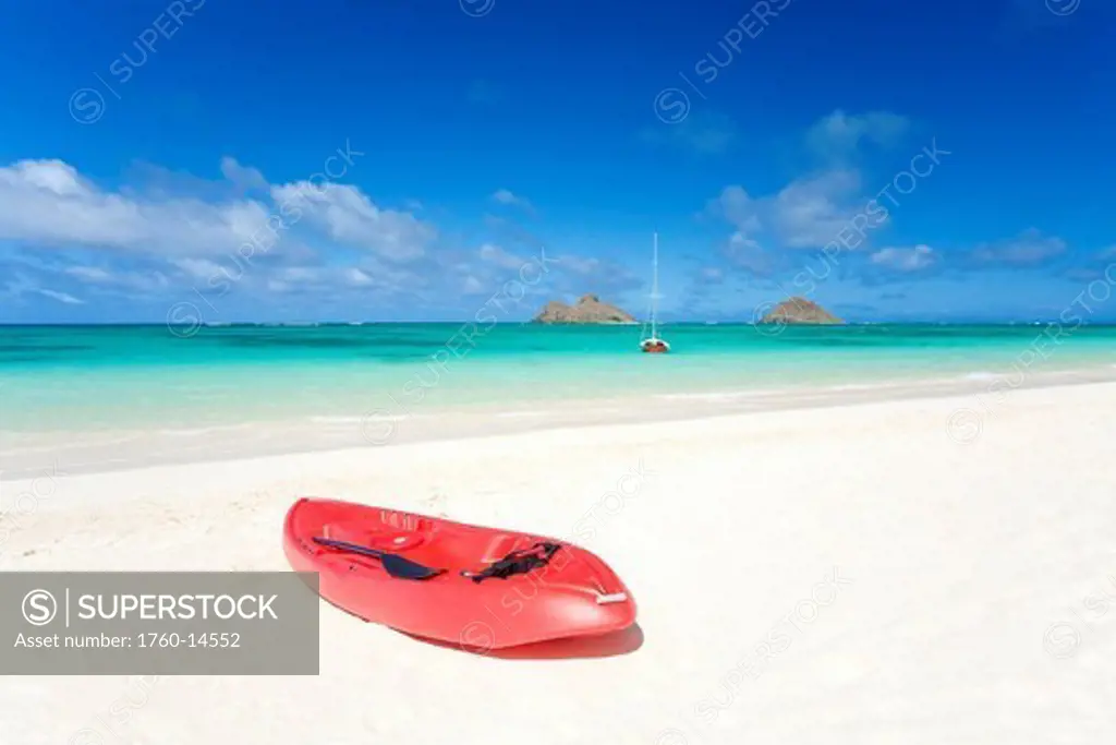 Hawaii, Oahu, Lanikai Beach, Red kayak on sandy shore, Mokulua Islands in distance.