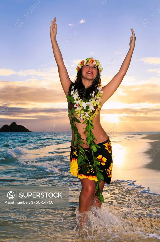 Hawaii, Oahu, Lanikai, Female hula dancer along beach shoreline at sunrise.