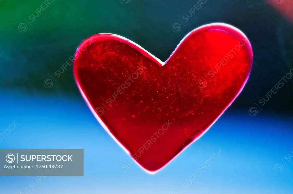 A heart shaped decoration is placed in window for Valentines Day, Outside background blurred.