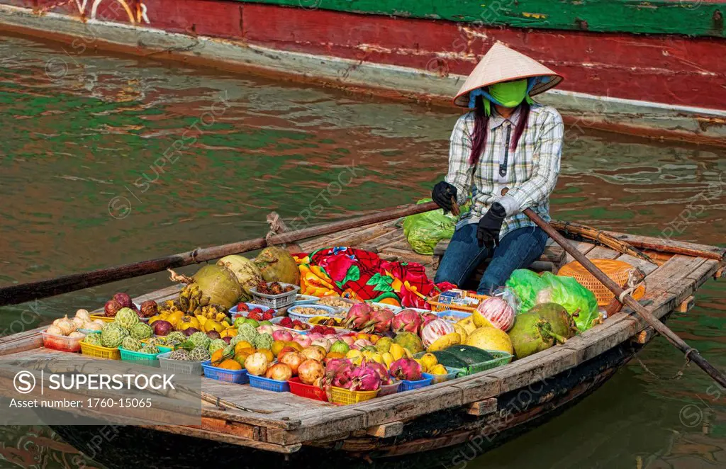 South East Asia, Vietnam, Ha Long Bay, Vietnamese woman sells fresh fruit from her small boat.
