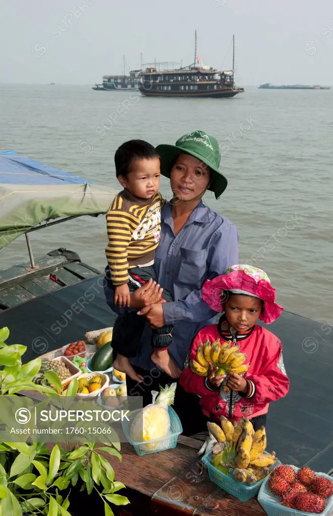 South East Asia, Vietnam, Ha Long Bay, Vietnamese woman and her children sell fresh fruit in harbor.