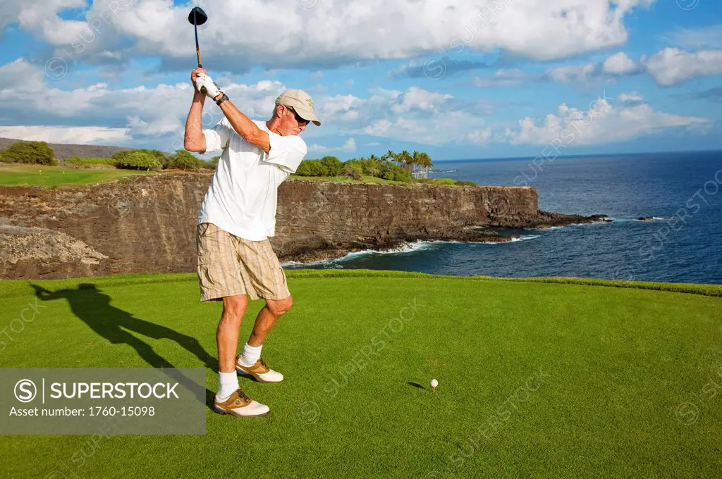 Hawaii, Lanai, Manele Golf Resort, Man tees off with Ocean view.