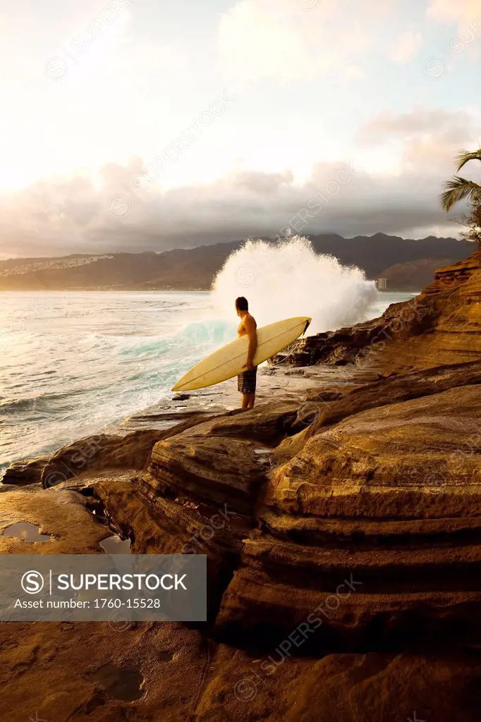 Hawaii, Oahu, Portlock, Male surfer admires view from China Walls. EDITORIAL USE ONLY