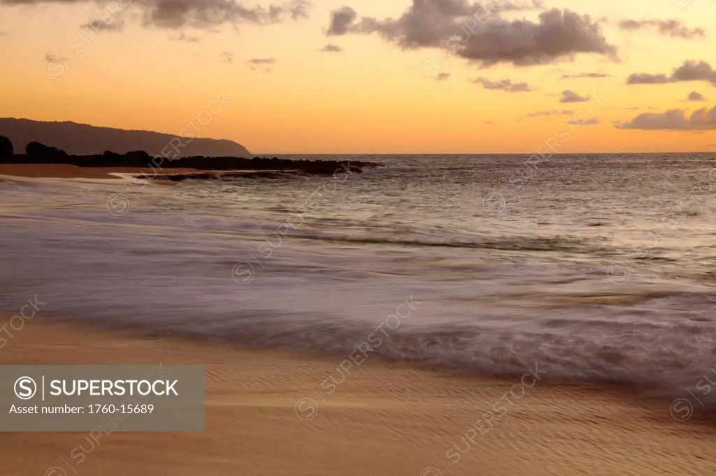 Hawaii, Blur of waves crashing on the beach at sunset
