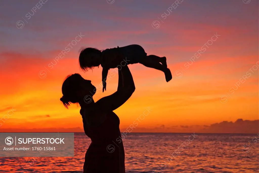Silhouette of a mother and child on the beach