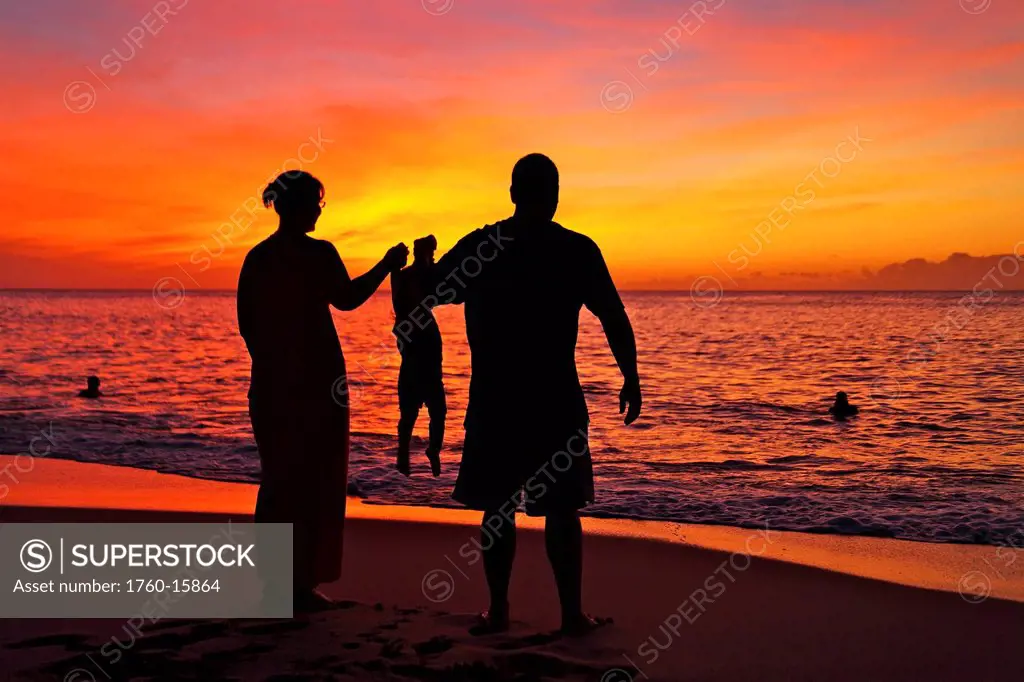 Silhouette of a family on the beach.