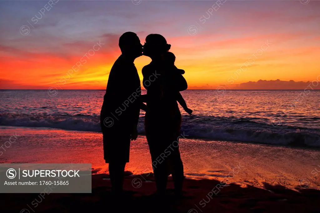 Silhouette of a family on the beach.