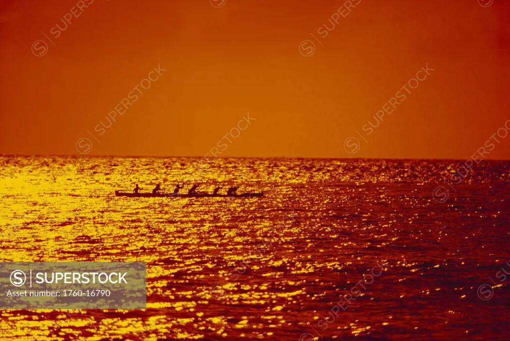 Hawaii, Silhouette of outrigger canoe, golden sunset.