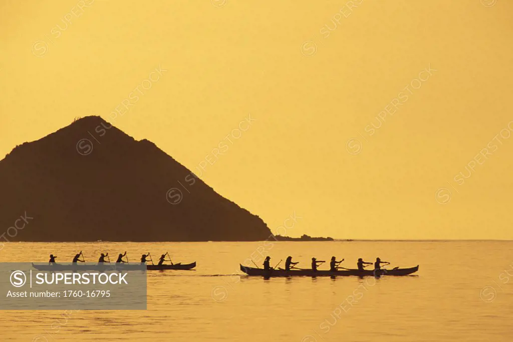 Hawaii, Oahu, Lanikai, 2 canoes silhouetted, orange sky/water Mokowa islands