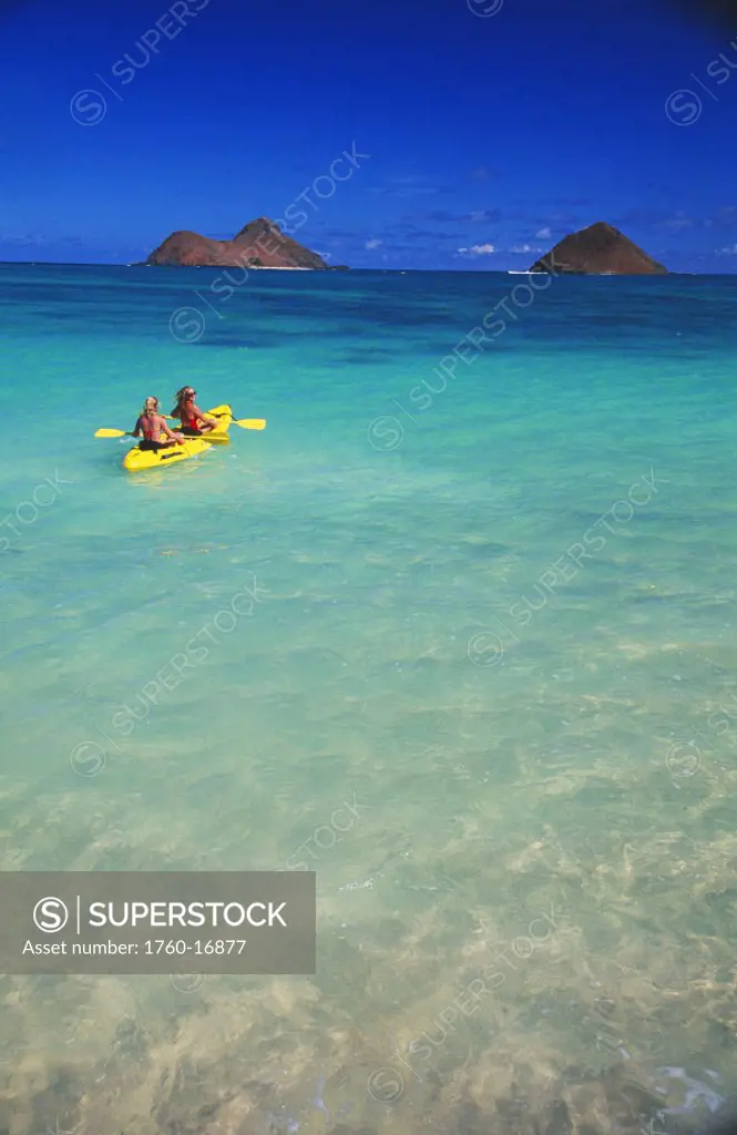 Hawaii, Lanikai, two women in yellow kayak, turquoise ocean, head to Mokulua Islands.
