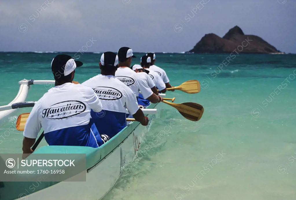 Hawaii, Oahu, Lanikai, Lanikai Canoe Club, Men paddling towards island, view from behind. NO MODEL RELEASE
