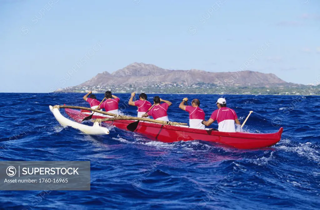 Hawaii, Oahu, Men paddling outrigger canoe, backside of Diamond Head in distance, view from behind. NO MODEL RELEASE
