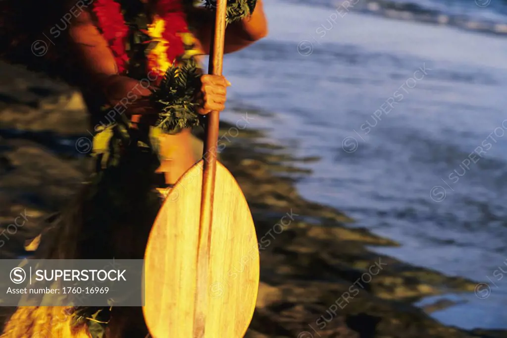 Hawaii, Detail of hands holding wooden paddle, afternoon lighting.