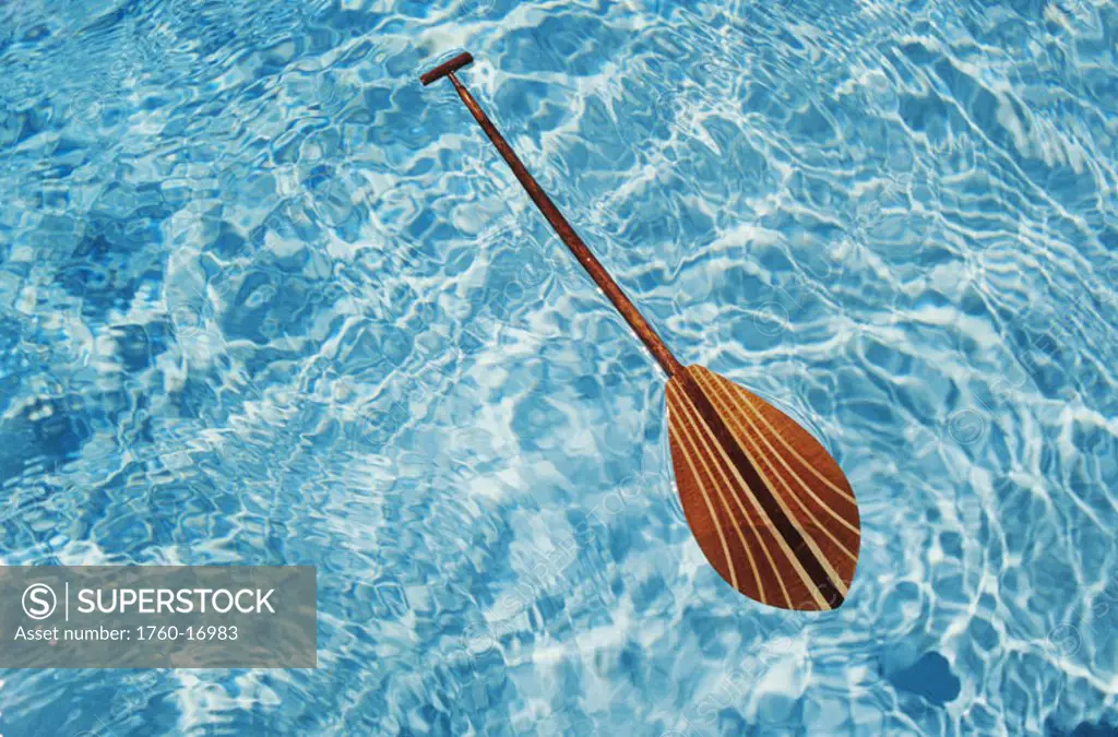 Overhead view of paddle floating on surface of turquoise water.