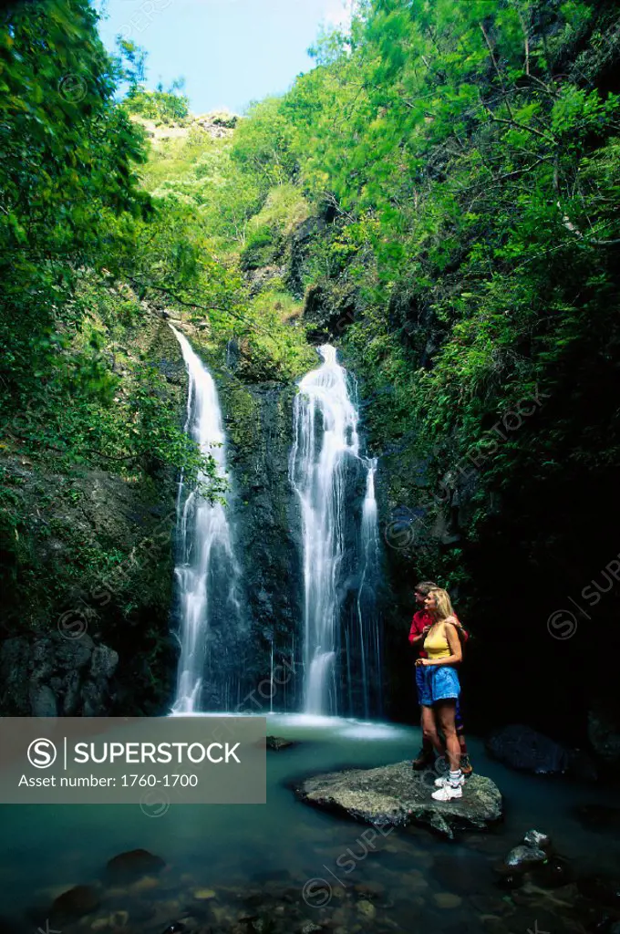 Maui, Mokumokuele Valley & rainforest, young couple at foot of waterfall B1604