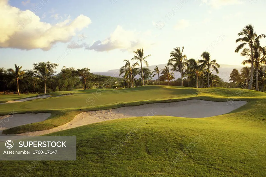 Hawaii, Maui, Wailea Golf Course, sand trap in foreground and hole with flag, afternoon lighting