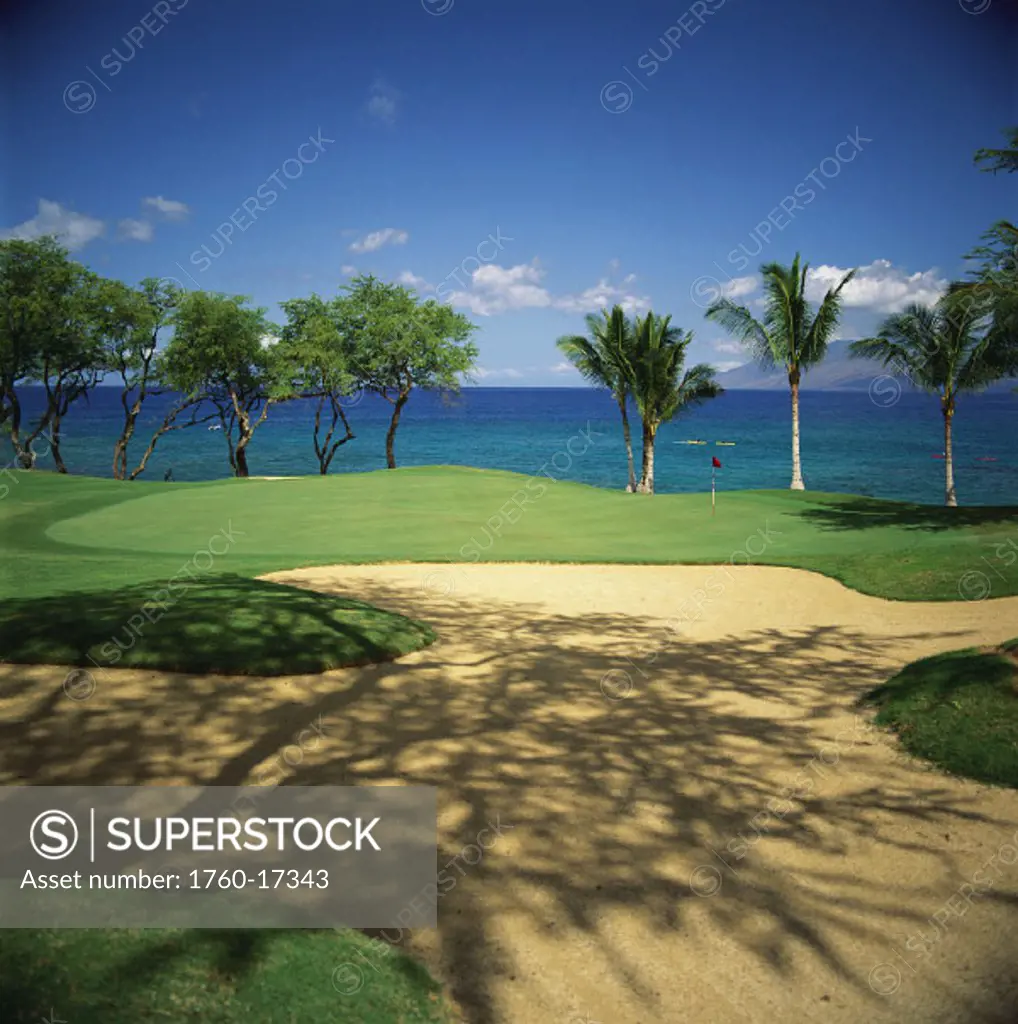 Hawaii, Maui, Makena Golf Club, hole#16, shadows on sandtrap, kayakers out in ocean