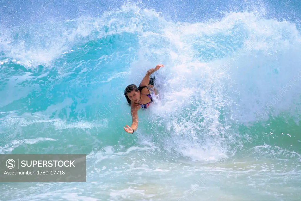 Hawaii, East Oahu, Sandy Beach, Woman bodysurfs in turbulent turquoise ocean