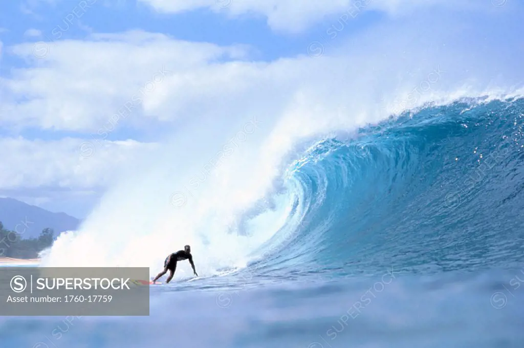 David Cantrell out in front of large crashing wave, blue sky w/ clouds