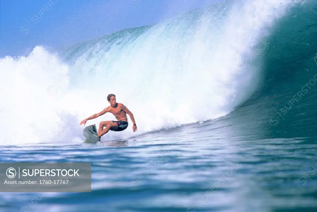 Hawaii, Johnson surfing big wave, crashing, glassy ocean in foreground