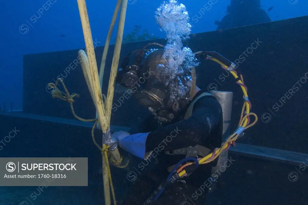 Hawaii, Oahu, A commercial hard hat diver working underwater.