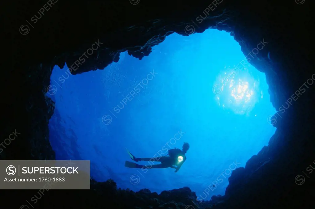 Hawaii, Silhouetted diver @ cavern entrance with flashlight, sunburst C1368