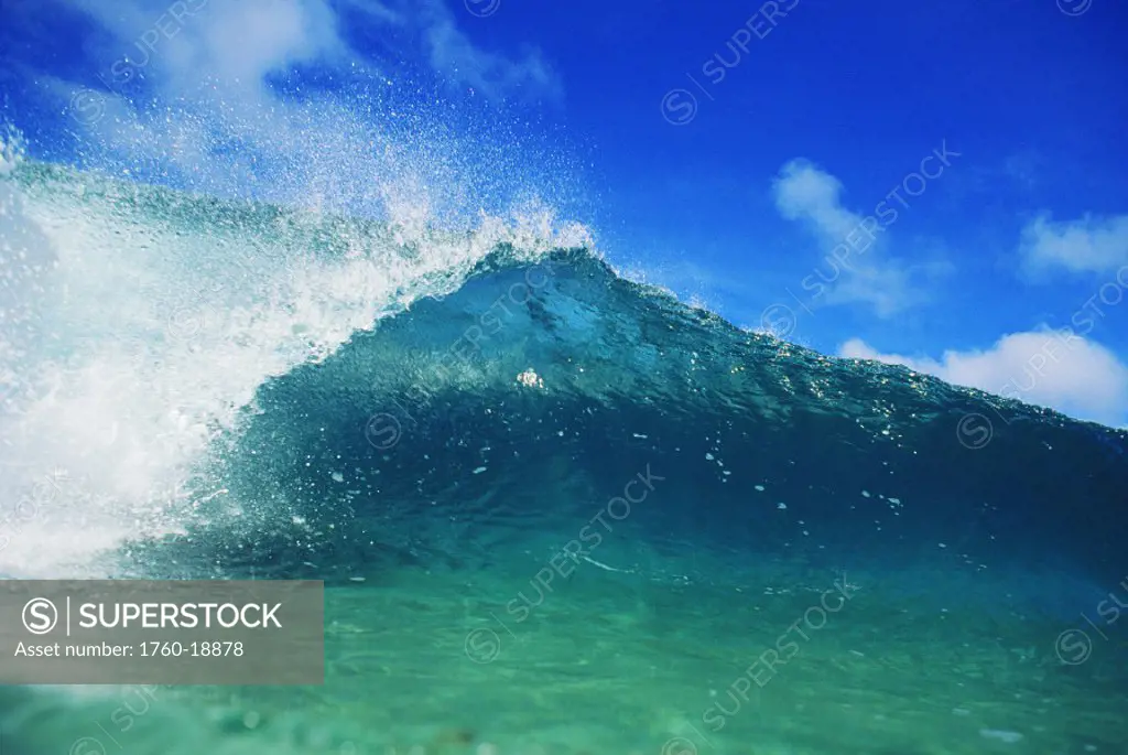 Hawaii, Glassy green wave, View from front of half curl, Blue sky in background.
