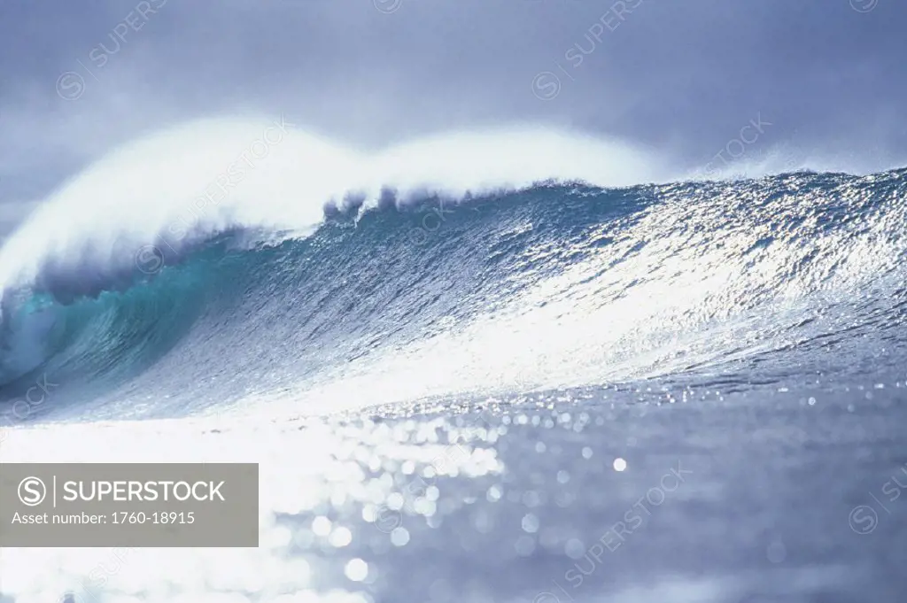 Hawaii, Oahu, North Shore, Pipeline, Big wave breaking at sunset, shimmery water.