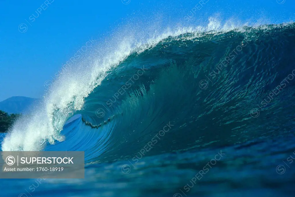 Powerful wave curling with blue skies in bkgd, Hawaii
