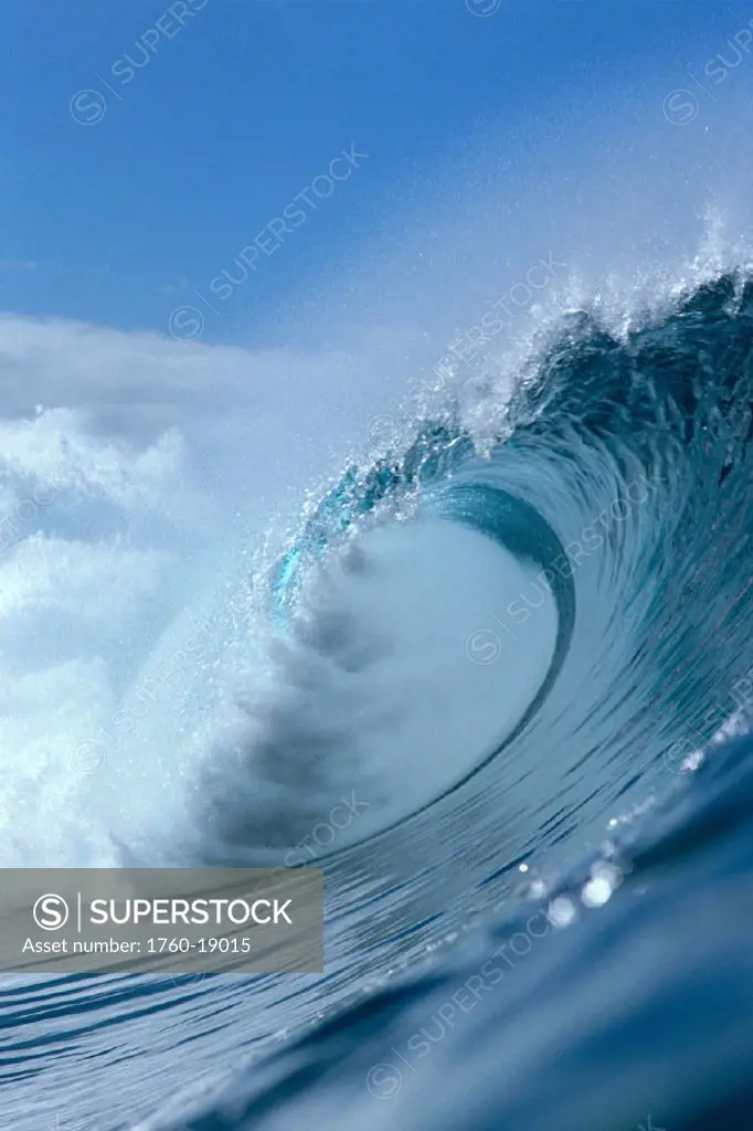 Pipeline, Side view of large wave curling, crystalline water, blue sky bkgd