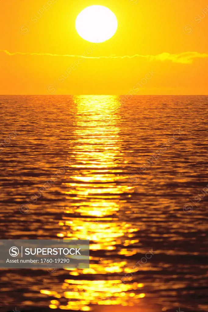 Golden sunset over ocean water, reflection on shimmering water